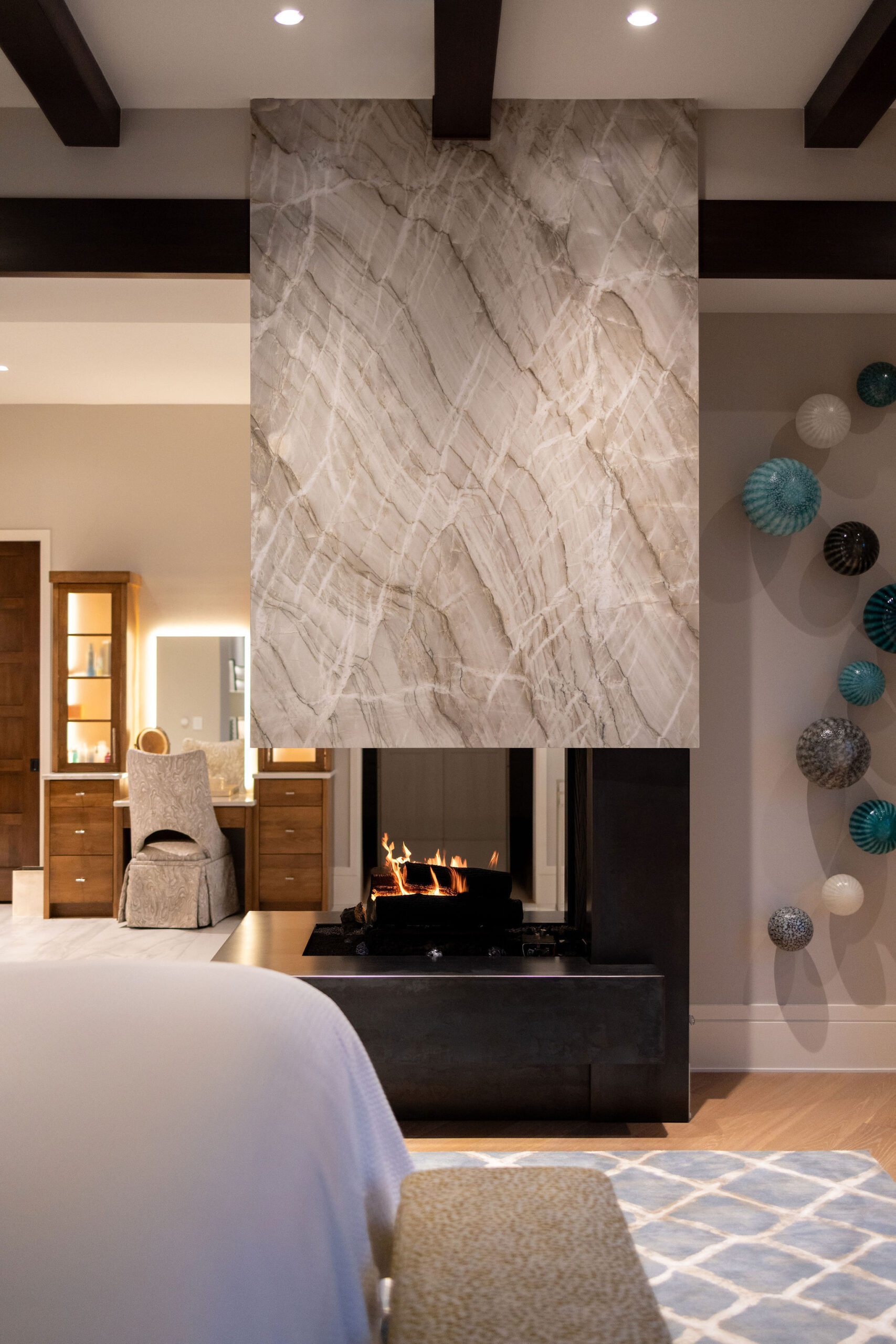 Luxury master suite with marble fireplace by Gabriel Builders