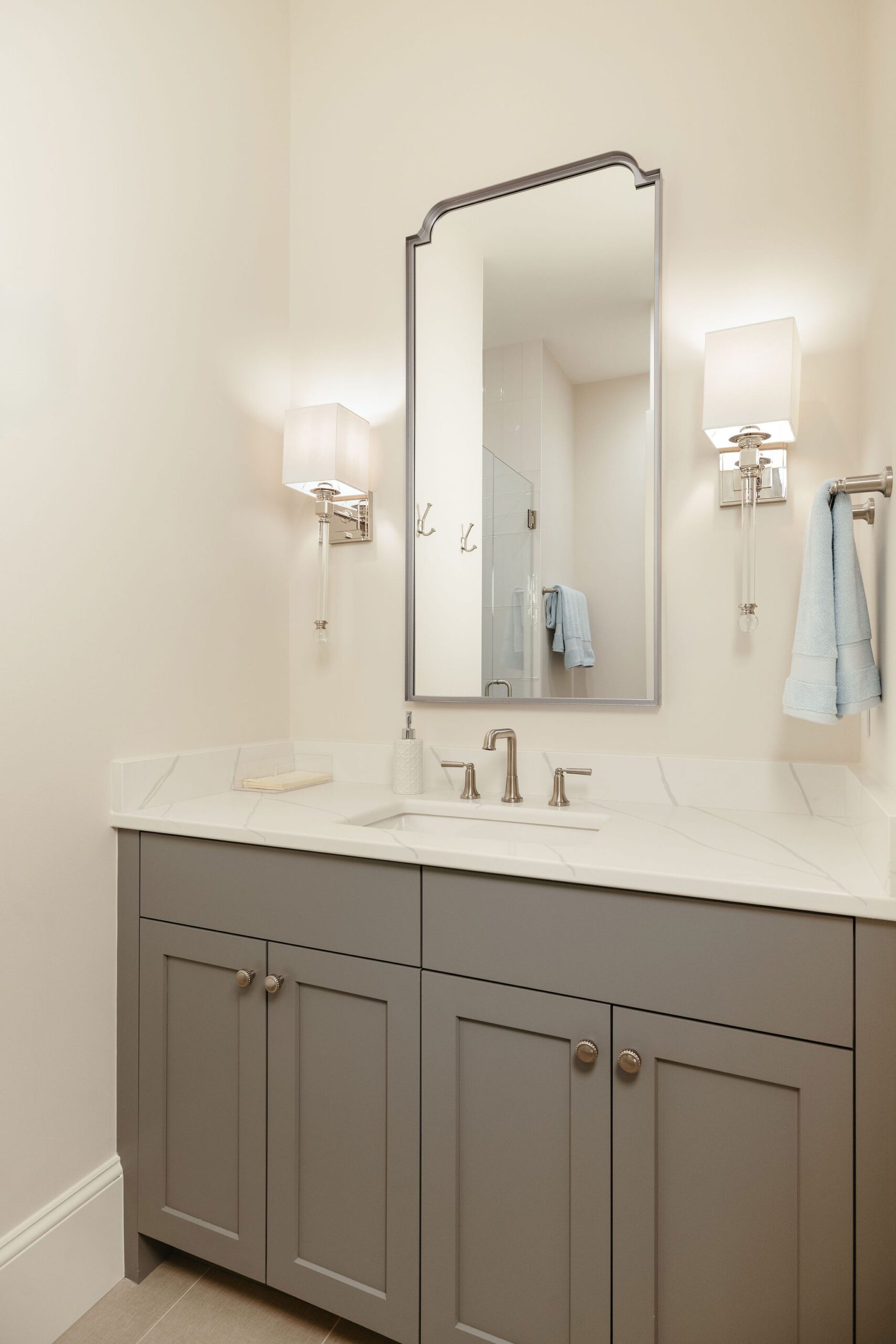 Modern bathroom with grey vanity and wall sconces