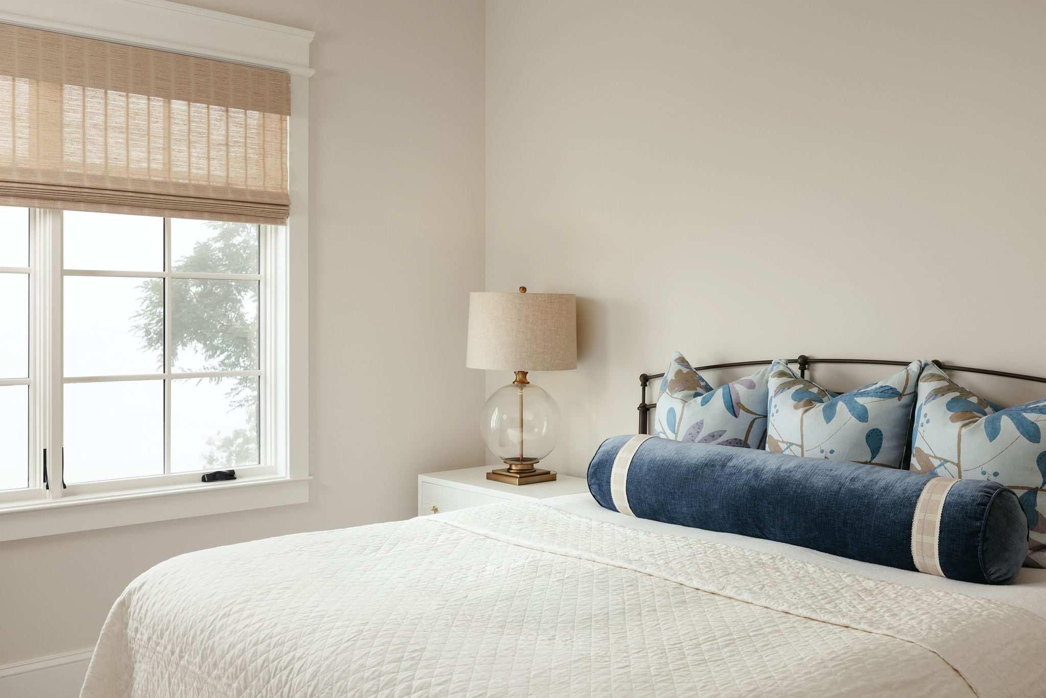 Guest bedroom with large windows and neutral palette