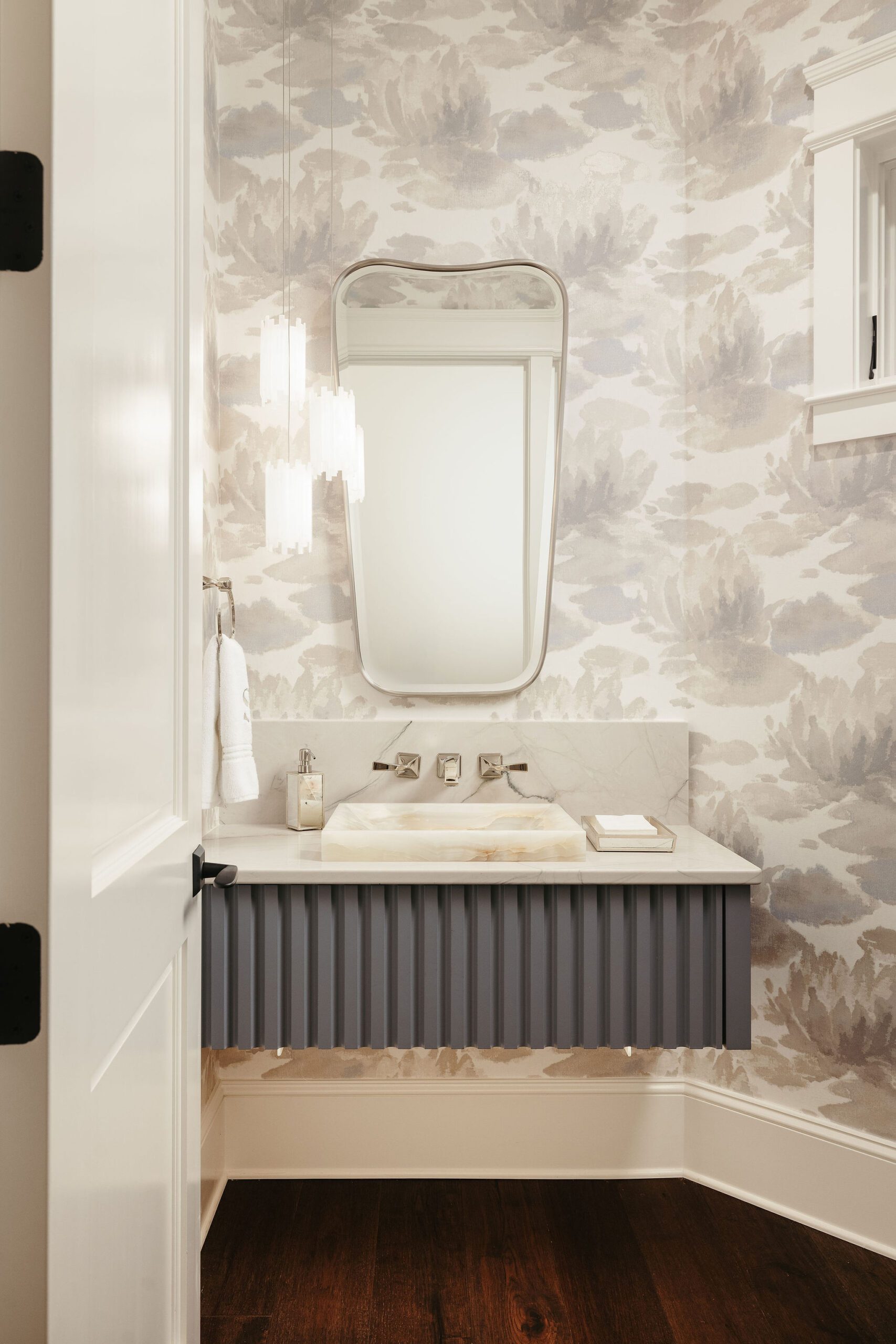Powder bath with patterned wallpaper and modern vanity