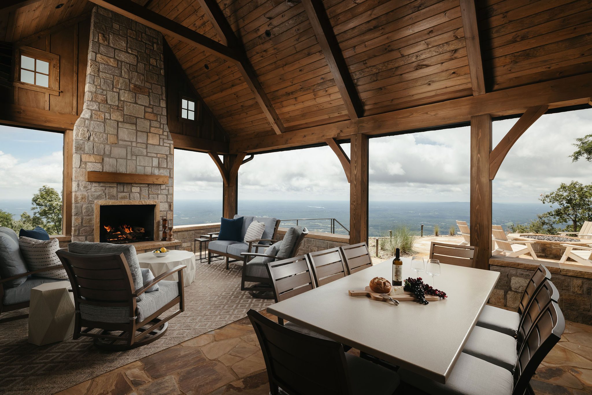 Outdoor seating area with stone fireplace and views