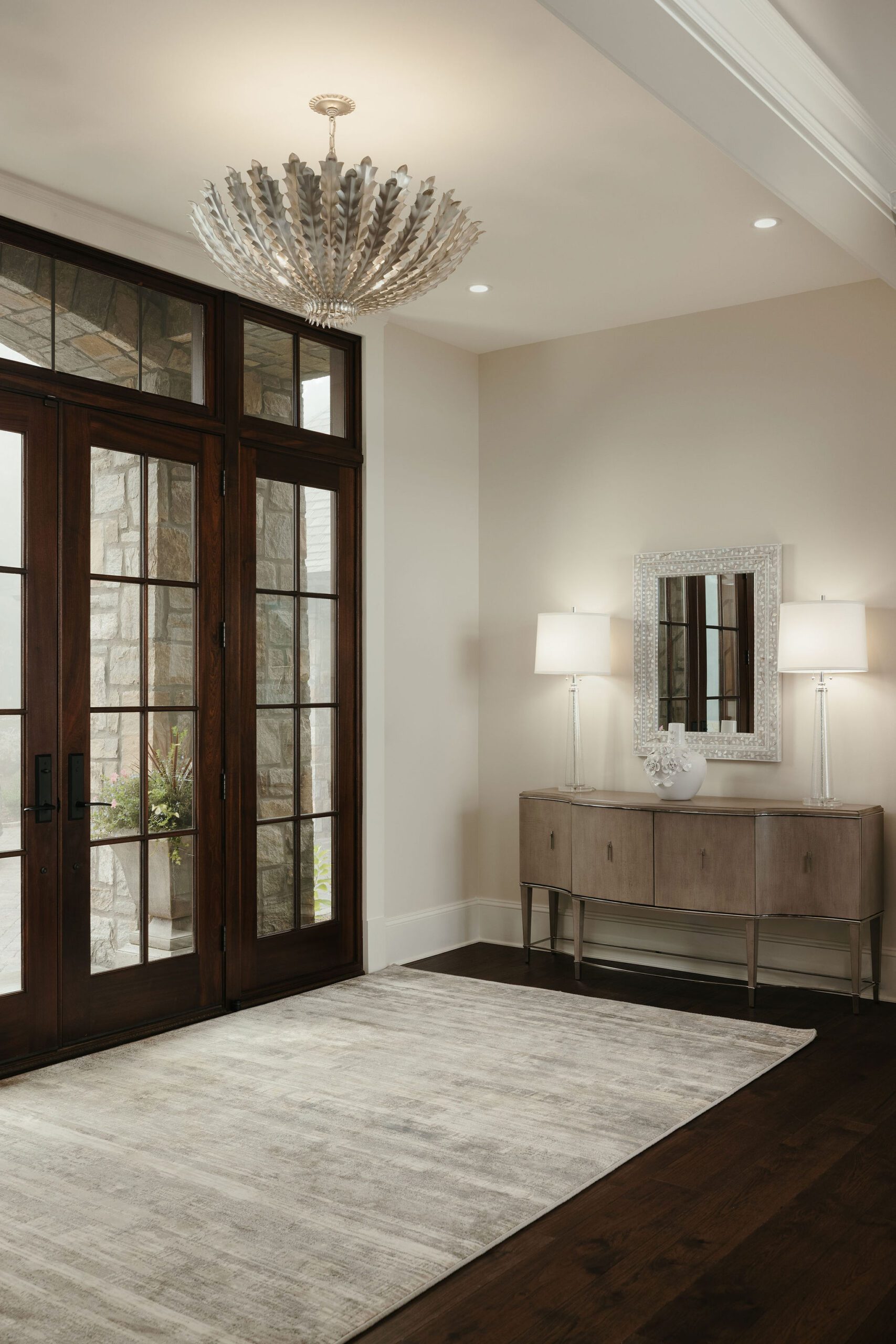 Elegant entryway with double wood doors and chandelier