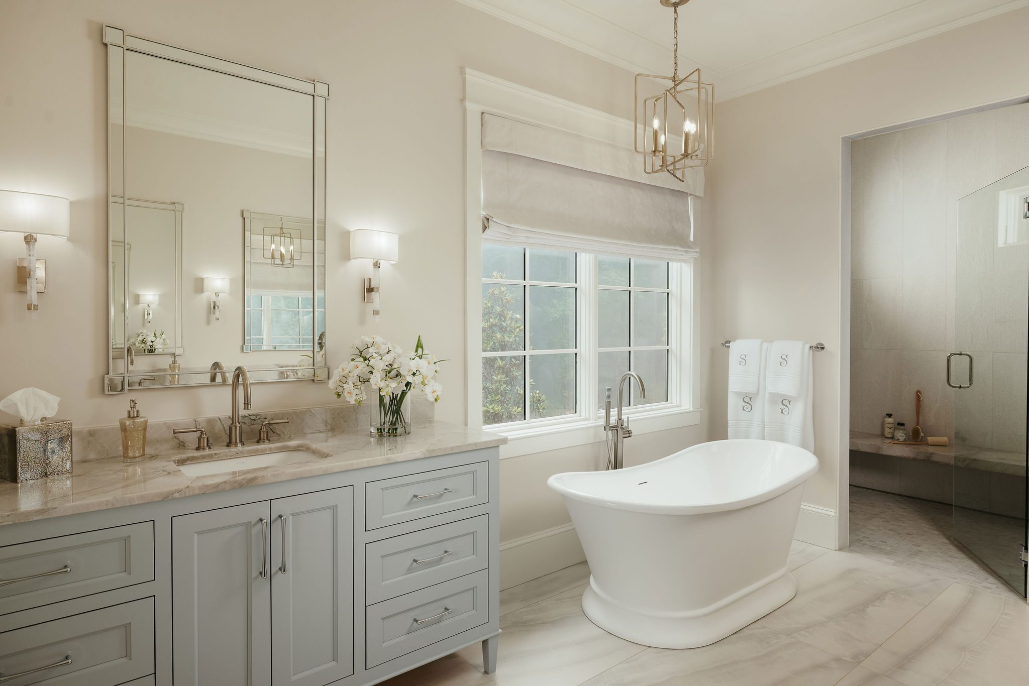 Spa bath with soaking tub, dual vanities, and natural light